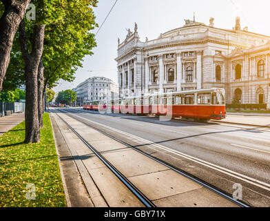 Wiener Ringstrasse with historic Burgtheater (Imperial Court Theatre) and traditional  electric tram at sunrise, Vienna, Austria Stock Photo