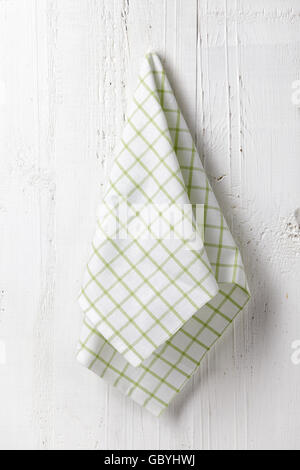 White green squared kitchen towel hanging on white wooden wall background Stock Photo
