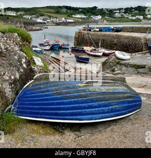 A blue rowing boat upside down in Coverack harbour Cornwall England UK A blue rowing boat upside down in Coverack harbour Cornwall England UK