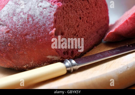 loaf of rustic beetroot bread on wooden cutting board Stock Photo