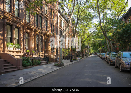 Tree-lined street with attractive brownstone buildings in affluent residential neighborhood in Brooklyn Heights, New York Stock Photo