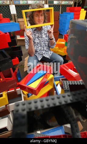 James May sits in a pile of lego bricks, at the Denbies Wine Estate, in Dorking, Surrey, where members of the public are helping with the construction of a full size house, using three million lego bricks for 'James May's Toy Stories.' Stock Photo