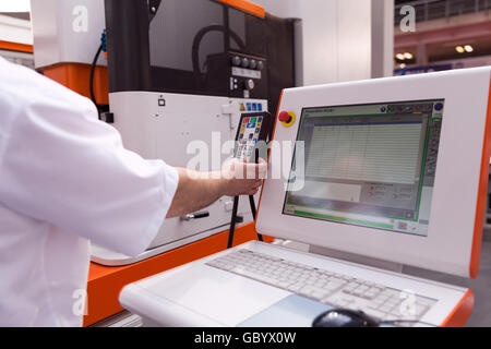 Technician working with computer numerical control (CNC) programmable machine. CNC technology. Stock Photo
