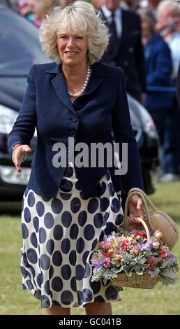 The Duchess of Cornwall carries a bouquet of flowers as she arrives at the Sandringham Flower Show on The Queen's estate in Norfolk. Stock Photo