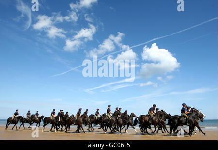 Soldiers from the Blues and Royals of the Household Cavalry Mounted Regiment exercise their horses on Holkham Beach in Norfolk, during their three-week summer training camp and a break from ceremonial duties. Stock Photo