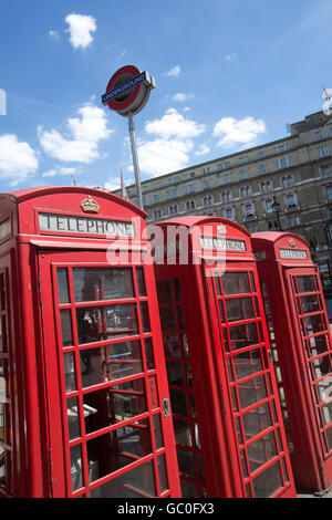 Red telephone boxes in a line outside Charing Cross train station, London, England, UK Stock Photo