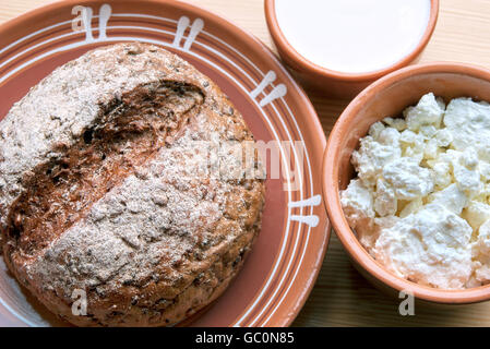 Rye-wheat bread with bowl of cottage cheese and sour cream Stock Photo
