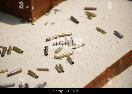 Bullets and spent cases on sand from hand gun Stock Photo