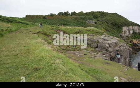 A general view of the scene in Benllech, Anglesey, where 11-year-old Paige Dean cheated death after jumping from her grandfather's car before it fell 50ft off a cliff edge and landed in the sea. The car travelled from top left of the picture and went over the cliff to the left of where the man is standing. Stock Photo