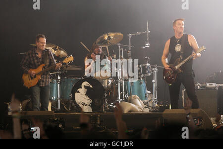 Crooked Vultures (left to right) John Paul Jones (formerly of Led Zeppelin), Dave Grohl (of Foo Fighters) and Josh Homme (of Queens of the Stone Age) performing a secret gig on the NME / Radio 1 Stage, during the Reading Festival, at Richfield Avenue, Reading. Stock Photo