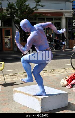 New York City:  Man, his body painted blue wearing a brief posing strap,  performing dance movements on Center Street Stock Photo