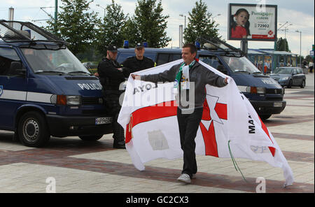 Northern Ireland fan showing his colours walks past the watching Polish Police at fans zone at Silesia City Shopping center in Katowice, Poland. Stock Photo