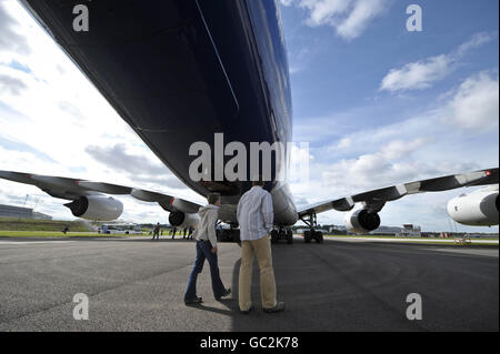 People walk underneath the tail section of test aircraft MSN1, an Airbus A380 Superjumbo jet, sits at Filton Airport, Bristol waiting to depart for Tolouse, France, after a tour around Europe and the UK where it is estimated that a million people have turned out to see the aircraft.