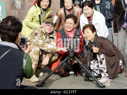 Japanese tourists pose for a photograph with a soldier during a display by the 1st Battalion The Royal Welsh in Chester City centre before their deployment on operations to Afghanistan. Stock Photo