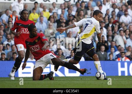 Tottenham Hotspur's Aaron Lennon (right) skips past Manchester United's Patrice Evra (centre) Stock Photo