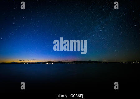 The Milky Way over Lake Winnipesaukee at night, at Ellacoya State Park, in Laconia, New Hampshire. Stock Photo