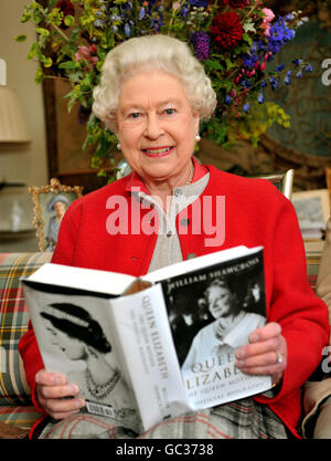 Queen Elizabeth II studies one of the first copies of ' Queen Elizabeth the Queen mother, the official biography', in a living room at Birkhall the Scottish home of the Prince of Wales and Duchess of Cornwall. Stock Photo