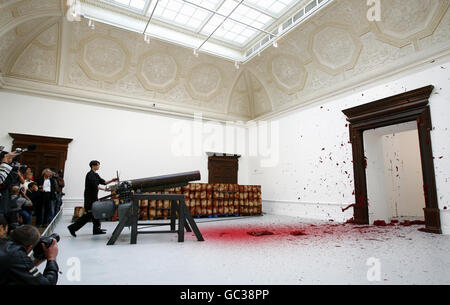 A projectile of red wax is fired into a corner by a cannon in Anish Kapoor's installation, Shooting into the Corner, 2008-09, during a press preview of a major solo exhibition of his work at the Royal Academy of Arts in central London. Stock Photo
