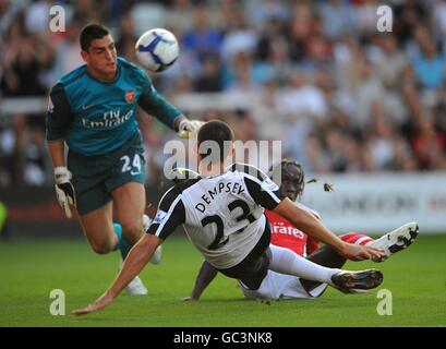 Soccer - Barclays Premier League - Fulham v Arsenal - Craven Cottage. Arsenal goalkeeper Vito Mannone (left) loks on as team mate Bacary Sagna battles for the ball with Fulham's Clint Dempsey Stock Photo