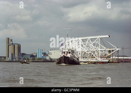 A quarter of the massive observation wheel's steel rim gets towed down the River Thames from Woolwich in London, to the South Bank near the Royal Festival Hall. The world's largest ferris wheel is scheduled to open to the public in January 2000. Stock Photo