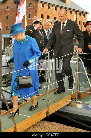 Queen Elizabeth II and the Duke of Edinburgh walk down a gangplank as they arrive at the Gloucestershire College, on the banks of the River Severn during a visit to the new building. Stock Photo