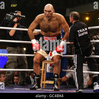 Russia's Nikolai Valuev lifts his 7ft 2 inch frame of his stool as his cornerman gives him advice during the WBA World Heavyweight Title bout at the Nuremberg Arena, Germany. Stock Photo