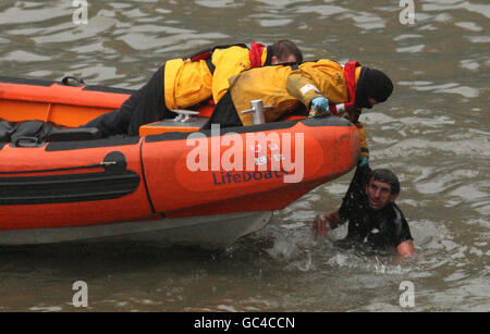 A man is rescued from the river Thames by the RNLI after jumping from Westminster Bridge in central London. Stock Photo