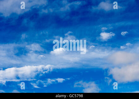 Small cirrostratus ,  cirrocumulus  and cirrus cloud formations  on  a sunny morning in early winter are contrasted a blue sky. Stock Photo