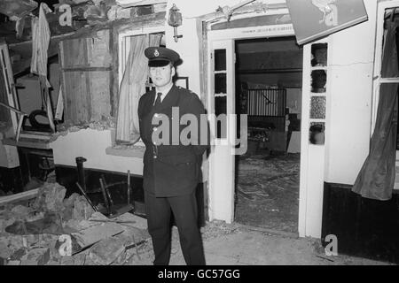 A police officer on duty outside the wrecked Horse and Groom public house in North Street, one of the two pubs near the centre of Guildford which were targeted by the IRA. Five people were reported killed and about 35 injured in this blast and at the nearby Seven Stars pub in Swan Lane. Both pubs were popular with local Guardsmen from nearby Pirbright and Aldershot. Stock Photo