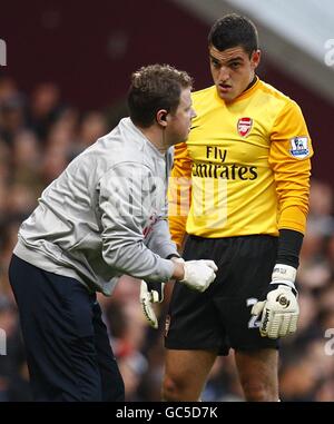 Arsenal goalkeeper Vito Mannone (right) recieves treatment for an injury Stock Photo