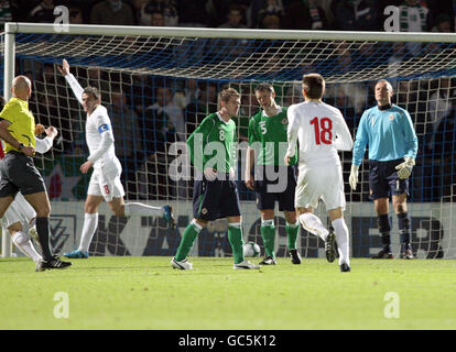 Northern Ireland's Steven Davis (centre left) and Stephen Craigan appear dejected after Serbia's Danko Lazovic (number 8) scored during the International Friendly at Windsor Park, Belfast. Stock Photo