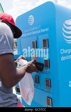 Young man using an AT&T mobile charging station - USA Stock Photo