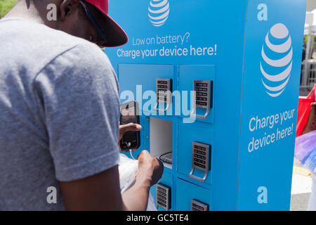 Young man using an AT&T mobile charging station - USA Stock Photo