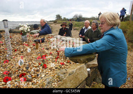 Members of the public add crosses and poppies to the memorial built by local man Willie Goldfinch to honour soldiers who have died in Iraq and Afghanistan on the beach at Langstone Harbour in Portsmouth. Stock Photo