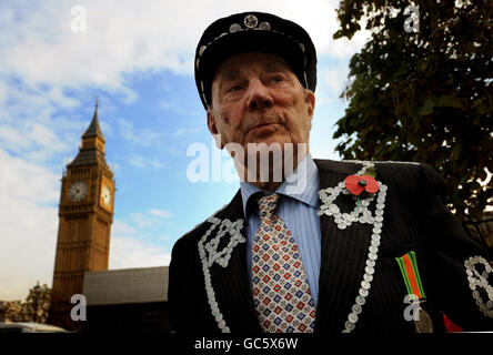 A gentlemen dressed in traditional costume wears a poppy prior to a two minute silence to commemorate Armistice Day in Parliament Square, London. Stock Photo