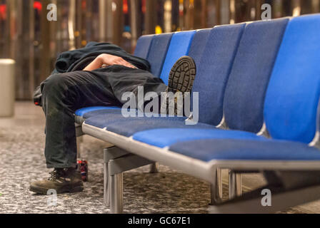 An unidentified homeless man sleeping overnight at Gatwick Airport. Stock Photo