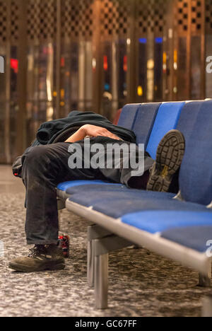 An unidentified homeless man sleeping overnight at Gatwick Airport. Stock Photo