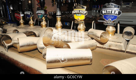 Glasses lay on the bar covered in mud and floodwater in The Bush pub on Cockermouth high street. Stock Photo