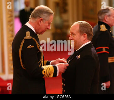 Lieutenant Commander Andrew Murray receives the Air Force Cross from the Prince of Wales during investitures at Buckingham Palace in London, for rescuing climbers caught in an avalanche on Buachaille Etive Mor, Glencoe in Scotland, in January.