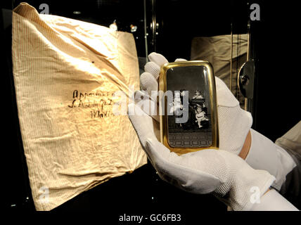 A cigarette case showing the Grand Duchess and grandchildren is seen beside a pillowcase in which the lots were smuggled out of Russia, displayed during the preview of 'Romanov Heirlooms: The lost Inheritance of the Grand Duchess Maria Pavlovna' at Sotheby's, London. Stock Photo