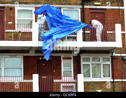 A team of forensic investigators cover up the outside of the flat on the Lynton Estate in Southwark, south east London, where a 4 year-old boy was found stabbed to death. Stock Photo