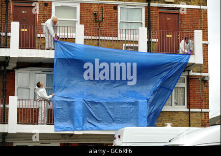 A team of forensic investigators cover up the outside of the flat on the Lynton Estate in Southwark, south east London, where a 4 year-old boy was found stabbed to death. Stock Photo