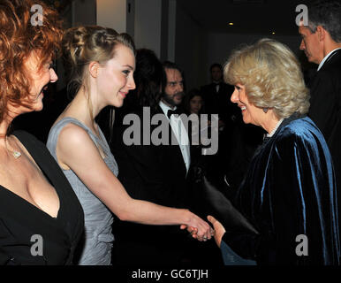 The Duchess of Cornwall shakes hands with actress Saoirse Ronan, after she and the Prince of Wales arrived at the Odeon Leicester Square in central London, for the Royal Film Premier of The Lovely Bones. Stock Photo