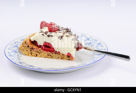 Piece of raspberry cheese torte with chocolate flakes and powdered sugar on a plate Stock Photo