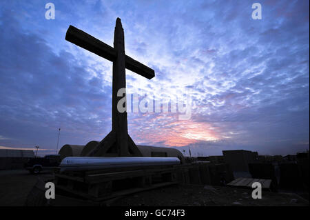 The sun sets behind the wooden cross of St Michael and All Saints Garrison Church in Camp Bastion, Helmand Province, Afghanistan. Stock Photo