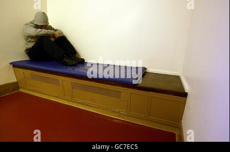 Picture posed by model. A man posing as a prisoner asleep in a cell as Greater Manchester Police launch their mock hotel brochure which is to be handed out to revellers to warn them of the consequences of alcohol fuelled violence during a night out. The brochure informs them of what a night at The Drunken Disorderly Inn can offer them. Stock Photo