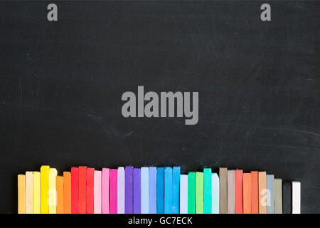 Colorful chalks lined up on blackboard background banner Stock Photo