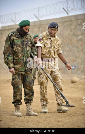 British soldiers and interpreters teach Afghan National Army soldiers counter Improvised Explosive Device (IED) searching techniques using hand-held electronic detectors at camp Shurabak, Helmand Province, Afghanistan, as part of the ongoing training by coalition forces. Stock Photo