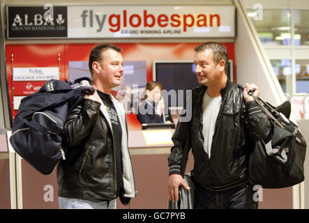 Flyglobespan customers Neil Cochrane (left), aged 38, and John Blake (right), aged 40, at the Flyglobespan desk inside Glasgow Airport following the announcement that the company has gone into administration. Stock Photo