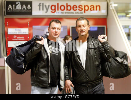 Flyglobespan customers Neil Cochrane (left), aged 38, and John Blake (right), aged 40, at the Flyglobespan desk inside Glasgow Airport following the announcement that the company has gone into administration. Stock Photo